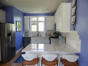 Purple kitchen with white quartz countertops.