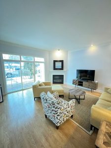 Living Room. White room with wood flooring. Yellow chair. Spotted chair. Television.