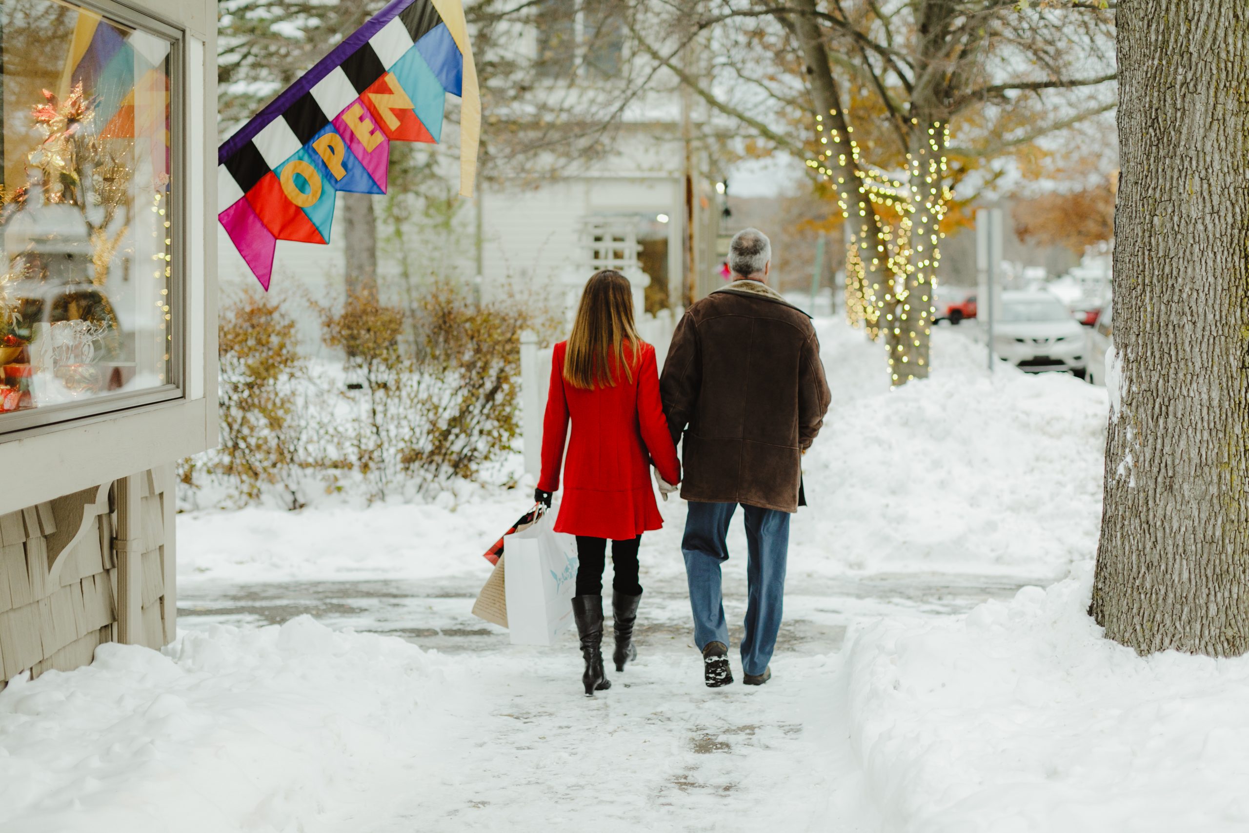 Man and woman walking down sidewalk during winter