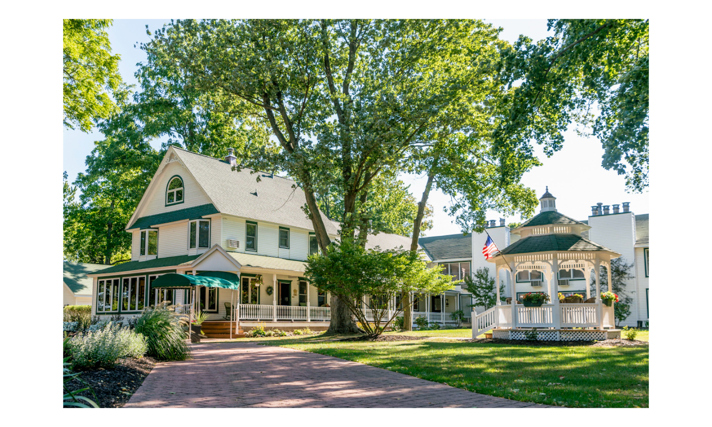 Outside photo of large white bed and breakfast. There is a gazebo in front of the building.